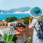 Tourist female with blue sun hat and travel backpack enjoying greek vivid colored Assos town