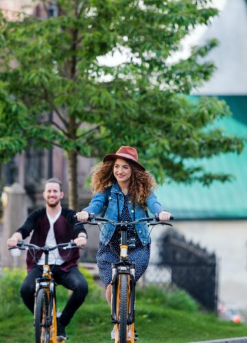 Young tourist couple travellers with electric scooters in small town