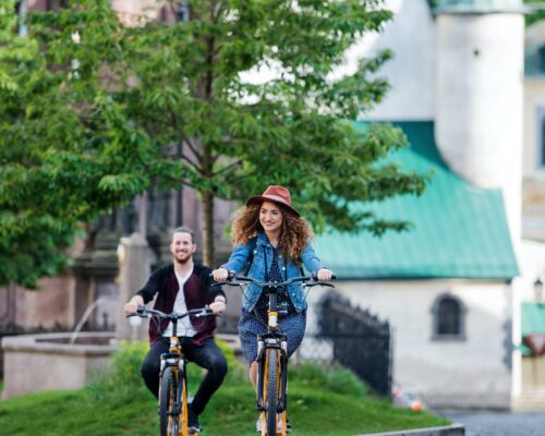 Young tourist couple travellers with electric scooters in small town