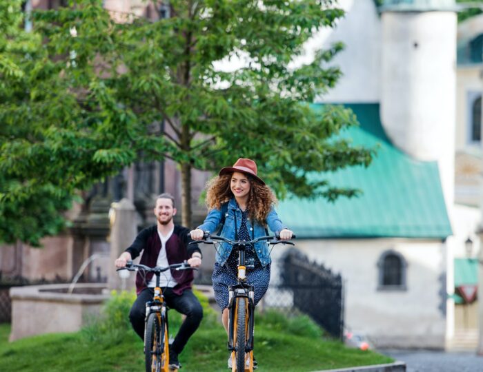 Young tourist couple travellers with electric scooters in small town