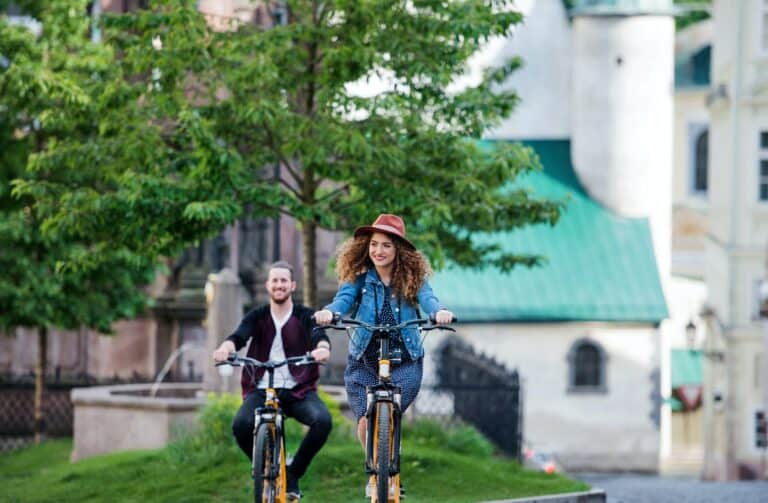 Young tourist couple travellers with electric scooters in small town